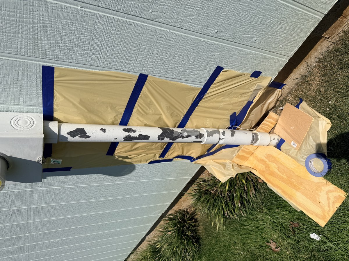 Electrical meter mast masked for painting