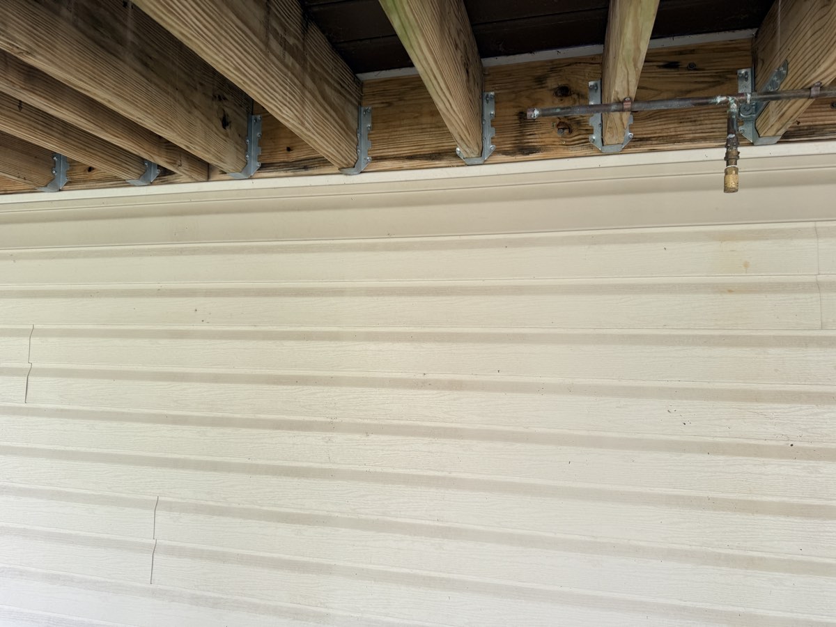 Replaced siding piece fitted under the deck
