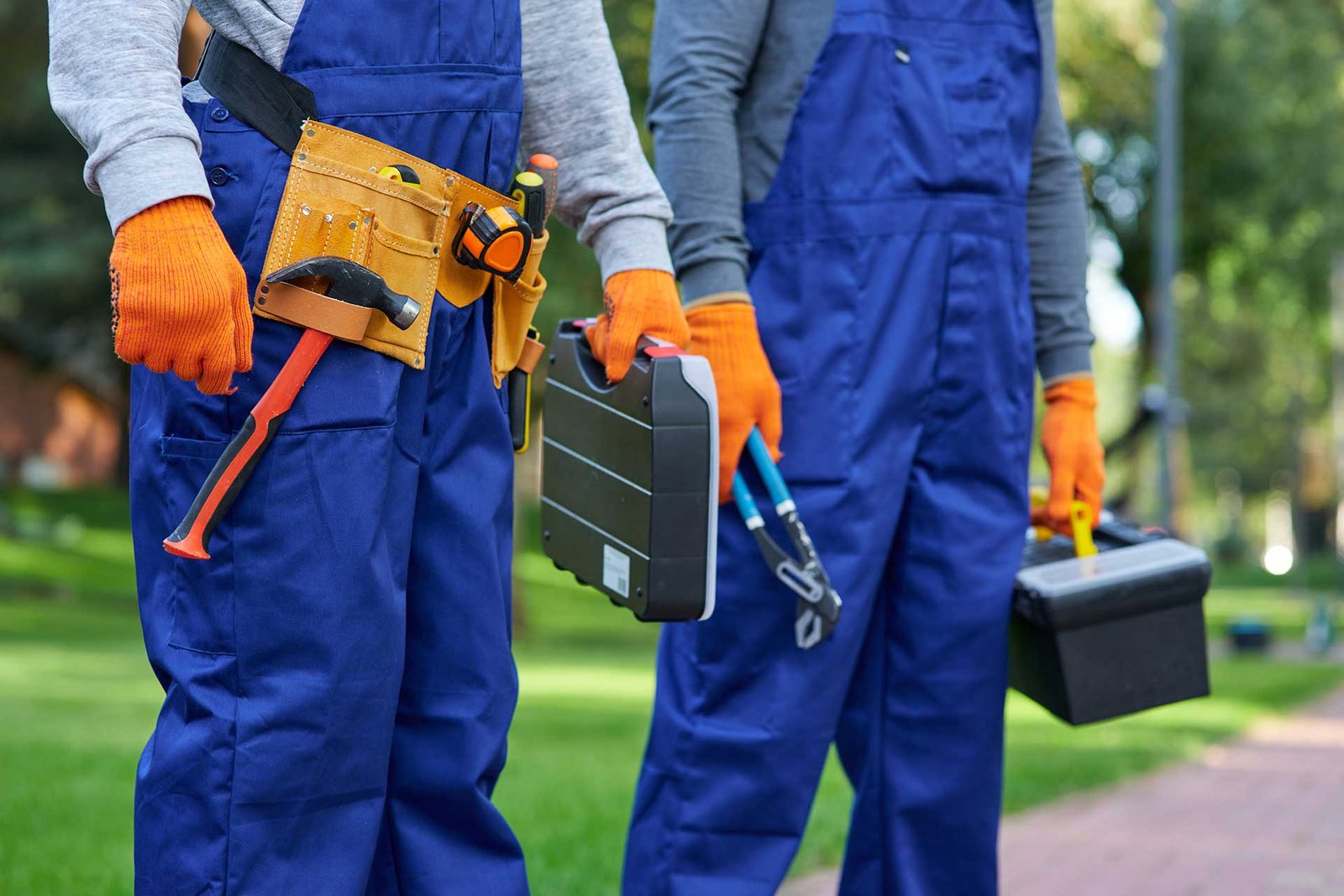 Workers holding tools and toolboxes outdoors