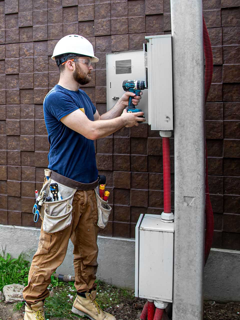 Electrician installing outdoor electrical panel