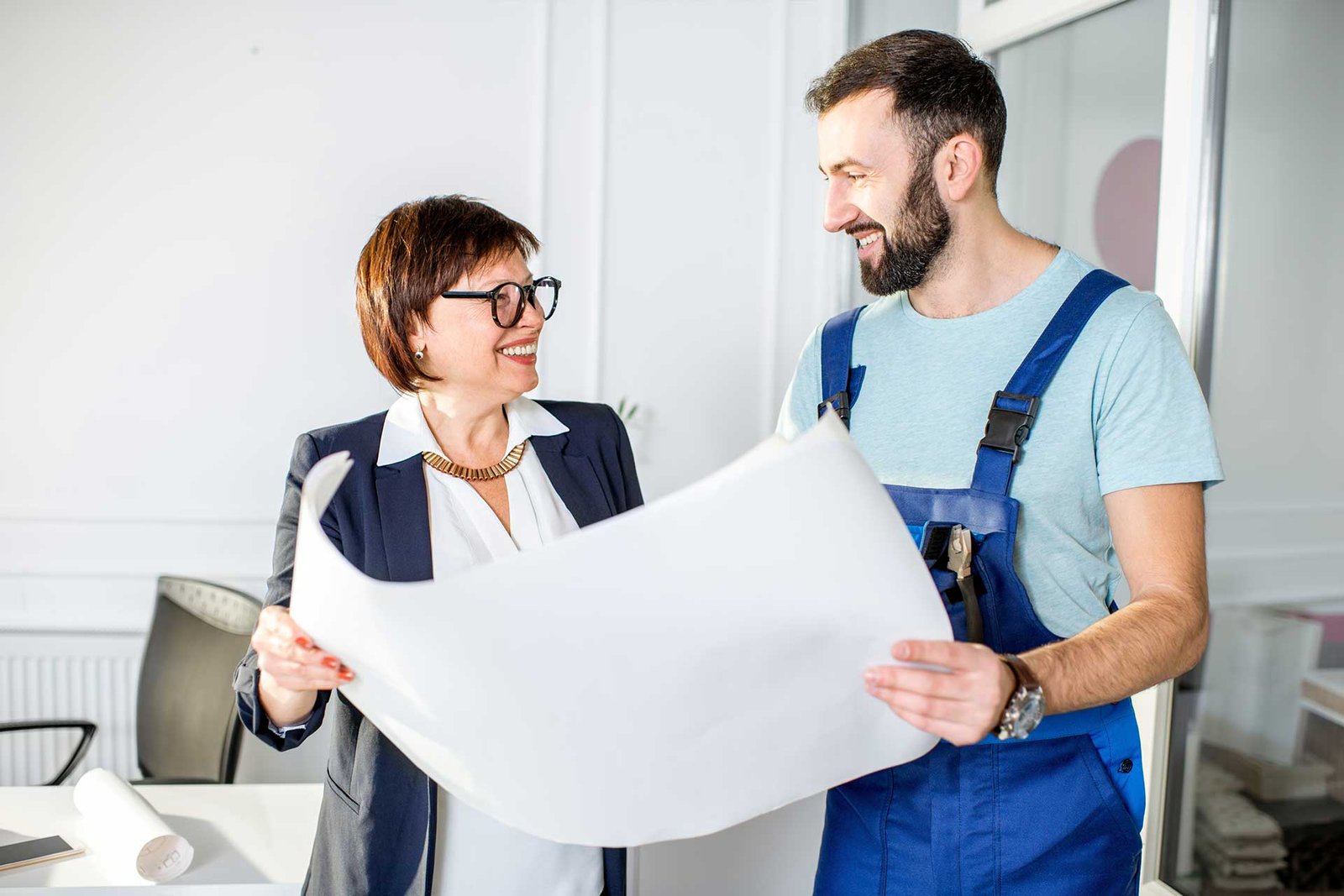 Plumber and businesswoman discussing building plans together